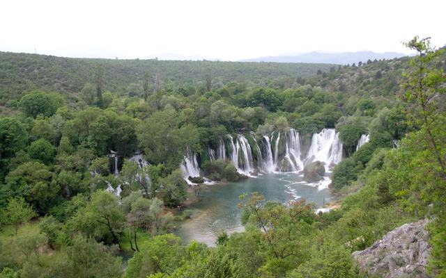 De Kravica-watervallen met een groene zwempoel in Herzegovina