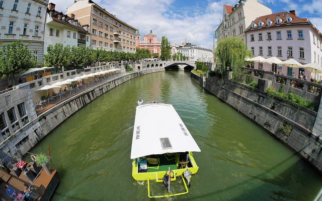 De Ljubljanica-rivier en de oude stad van Ljubljana met het kasteel op de heuvel