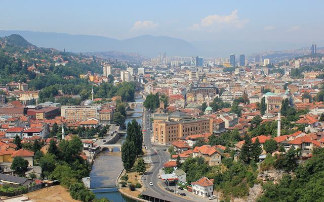 Uitzicht over Sarajevo met minaretten en de omliggende bergen